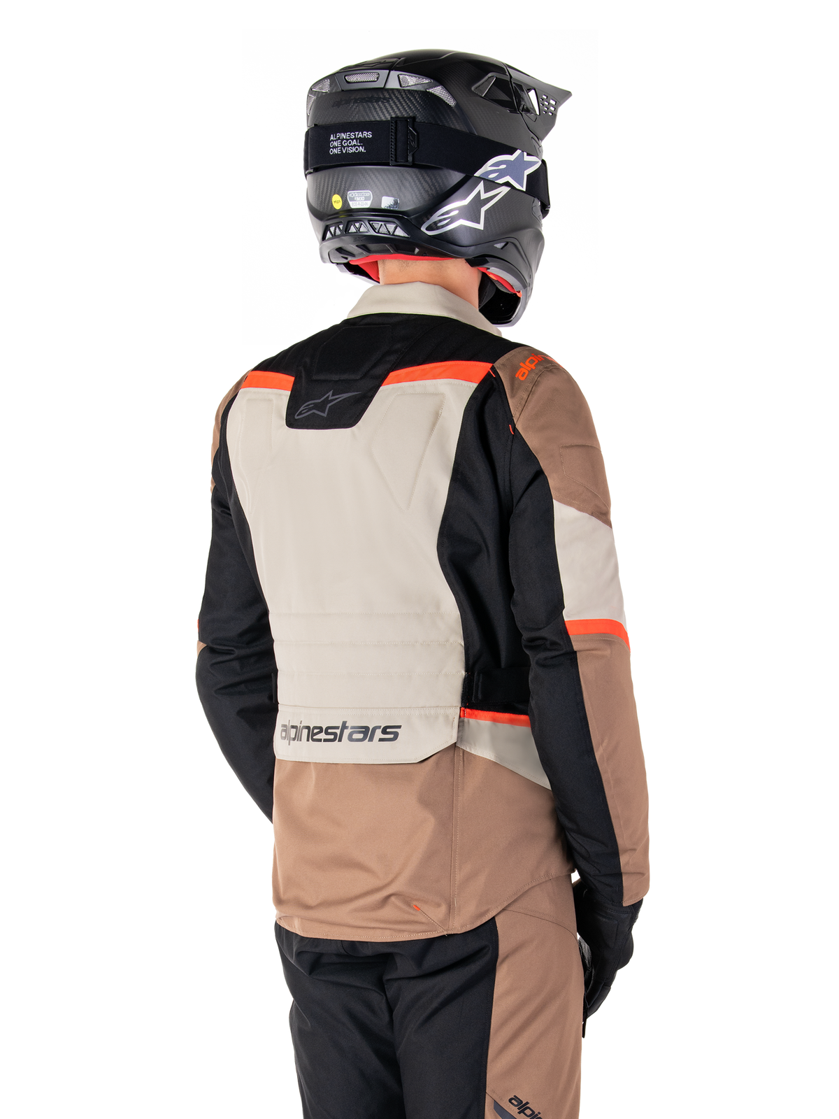 Giacca Alpinestars ST-1 Waterproof, giacca adventure touring, Dark Khaki Sand Black Red Fluo, vista posteriore con pannelli in tessuto a blocchi di colore, dettagli rosso fluorescente e marchio Alpinestars sulla parte inferiore della schiena, indossata da un pilota con casco nero