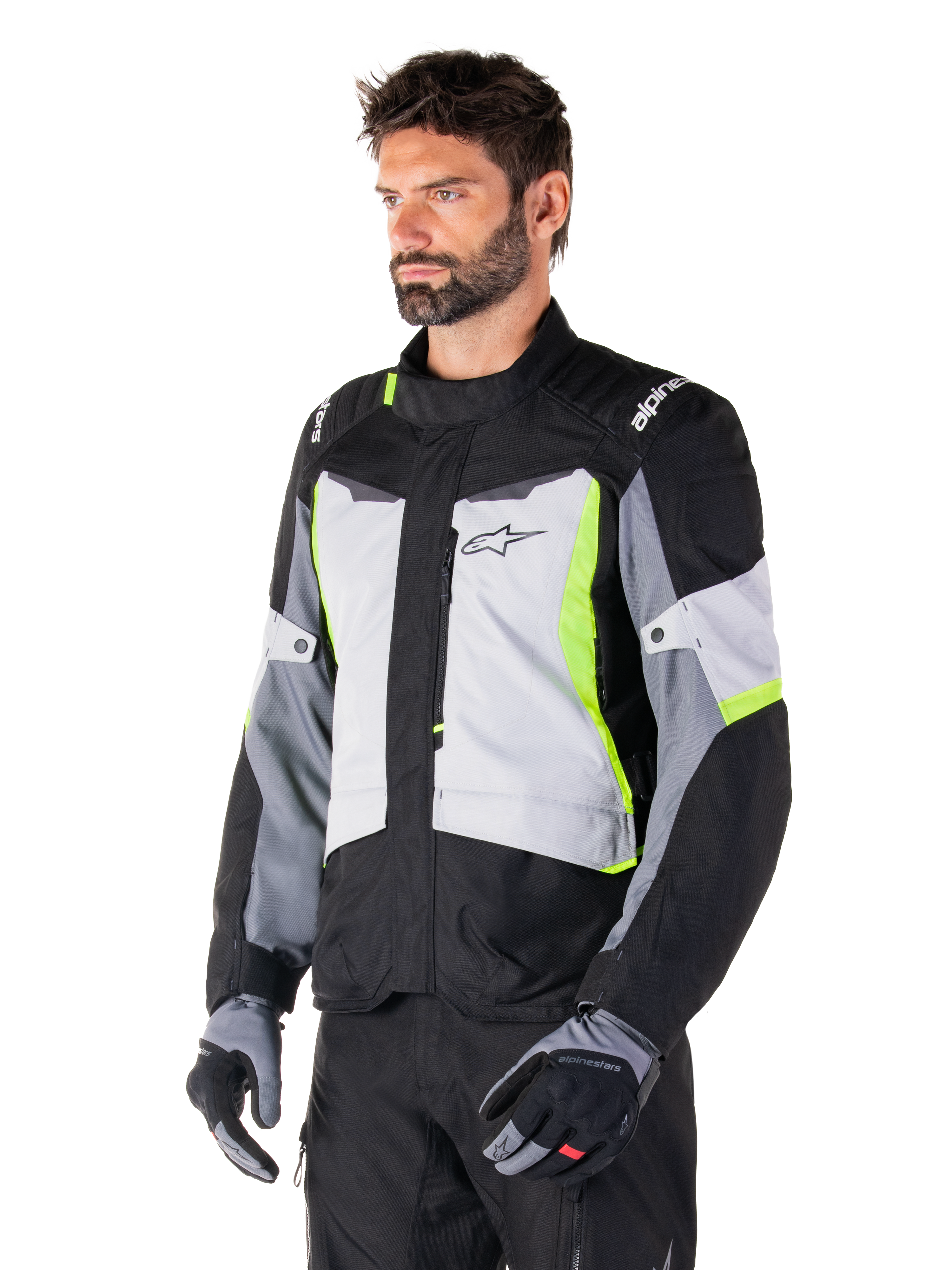 Alpinestars ST-1 Waterproof Jacket, Ice Gray Black Yellow Fluo, worn by a man with matching gloves and black pants, featuring gray torso panels with fluorescent yellow accents, black shoulders with white branding, adventure touring design for road riding
