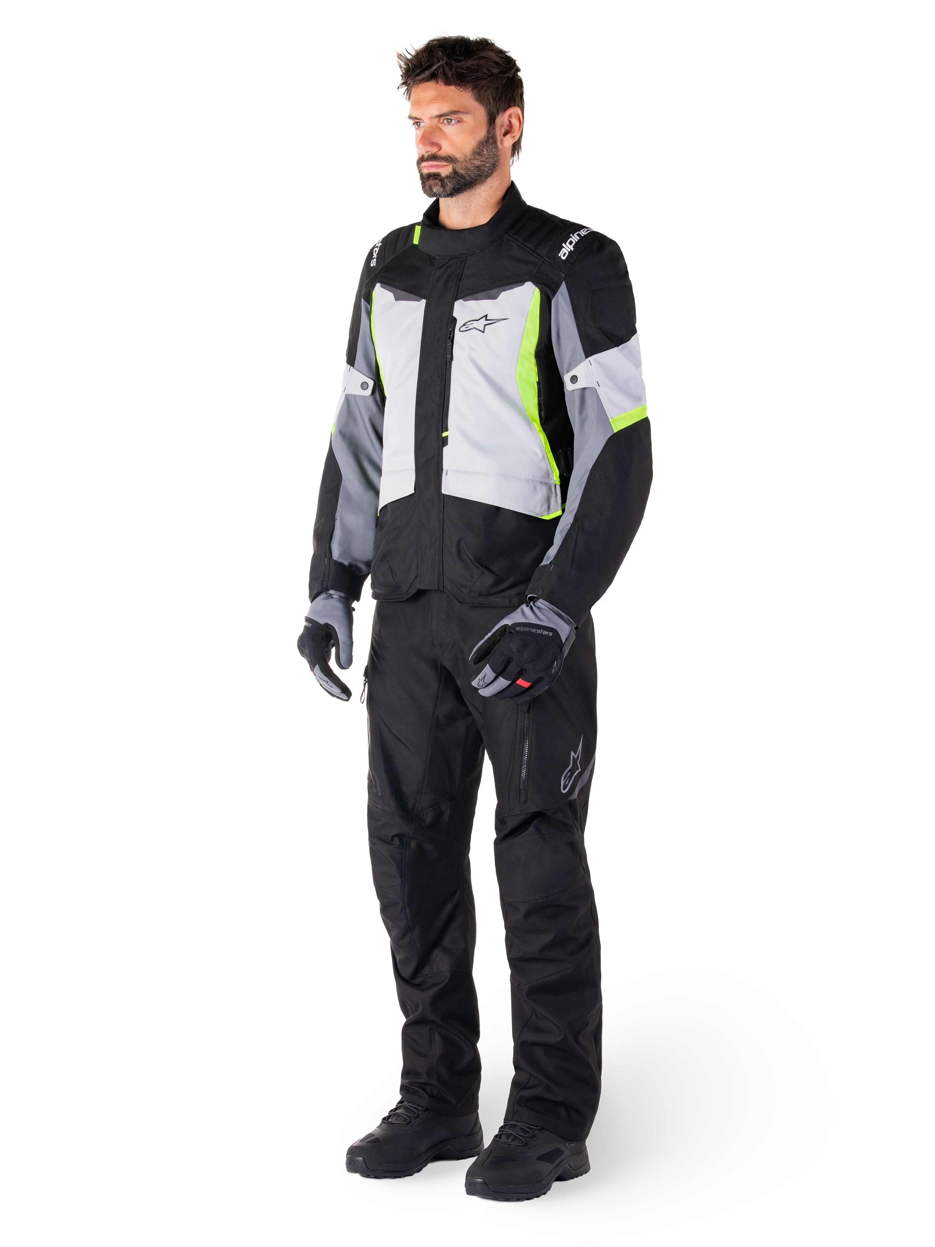 Alpinestars ST-1 Waterproof Jacket, Adventure Touring Motorcycle Jacket, Ice Gray Black and Yellow Fluo, worn by a model with matching black pants and gloves, featuring a streamlined design with bright yellow accents and Alpinestars branding.