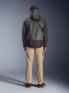 Alpinestars Giacca Mospher Waterproof, parka da moto nero visto dal retro, con logo MO.ST.EQ sulla parte superiore della schiena e struttura in tessuto ripstop, indossata con pantaloni cargo color sabbia e sneaker nere, stile urban commuter.