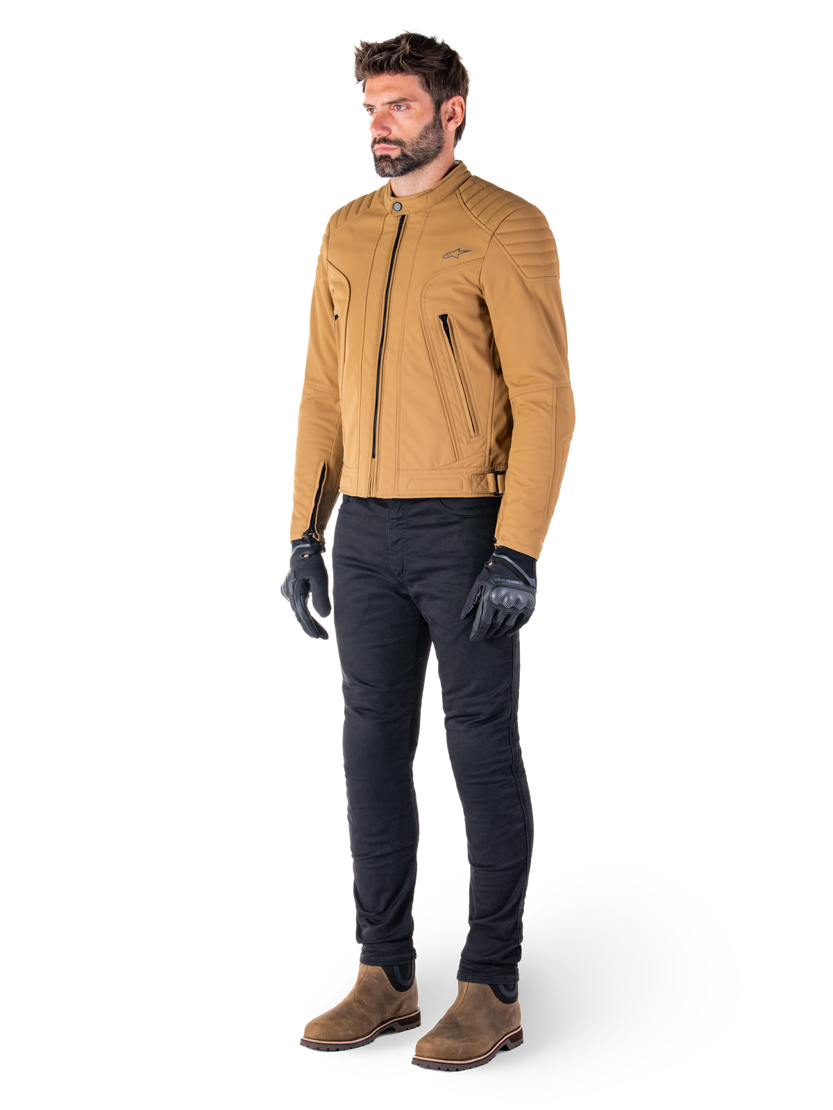 Motociclista che indossa la giacca Alpinestars Clayton WR in Utility Brown Light Gold, giacca da moto urban contemporary con dettagli trapuntati sulle spalle, abbinata a pantaloni neri, guanti neri e stivali marroni
