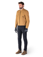Motociclista che indossa la giacca Alpinestars Clayton WR in Utility Brown Light Gold, giacca da moto urban contemporary con dettagli trapuntati sulle spalle, abbinata a pantaloni neri, guanti neri e stivali marroni