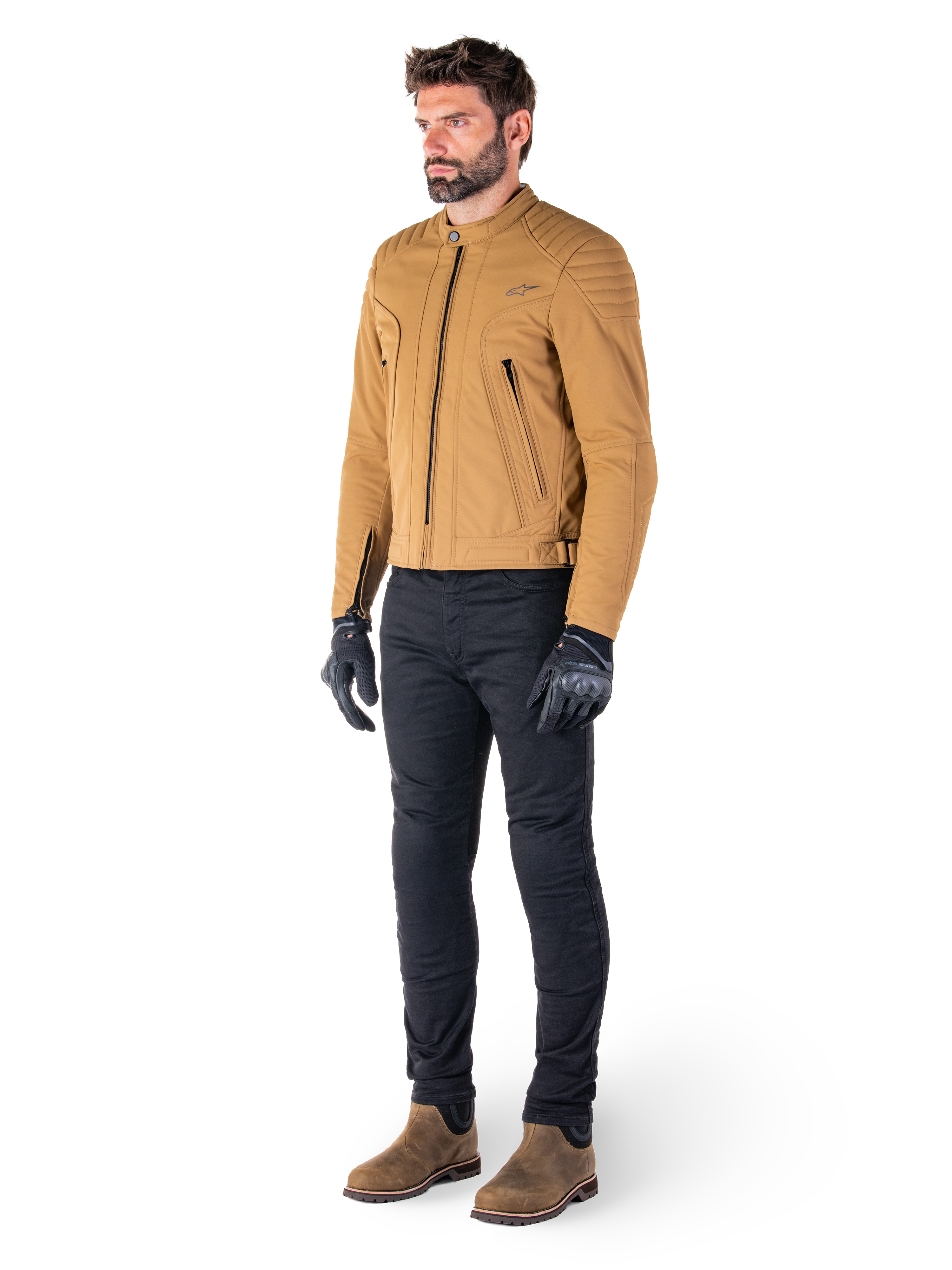 Motociclista che indossa la giacca Alpinestars Clayton WR in Utility Brown Light Gold, giacca da moto urban contemporary con dettagli trapuntati sulle spalle, abbinata a pantaloni neri, guanti neri e stivali marroni