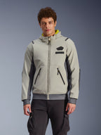 Alpinestars Moblast Waterproof Jacket, felpa con cappuccio da moto urbana grigio chiaro e grigio scuro con fodera gialla, tasche anteriori e cerniere nere, indossata con pantaloni cargo neri, design sportivo moderno