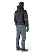 Alpinestars Mohobbs Waterproof Jacket, nero, vista posteriore di un bomber trapuntato imbottito con marchio verticale a rilievo sulla schiena, abbinato a pantaloni da guida grigi e guanti neri, abbigliamento da moto ispirato allo streetwear urbano