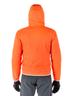 Alpinestars Giacca Mohobbs Waterproof, copertura antipioggia ripiegabile arancione fluo brillante, vista posteriore della giacca leggera con cappuccio, indossata con pantaloni da guida grigio scuro e guanti neri