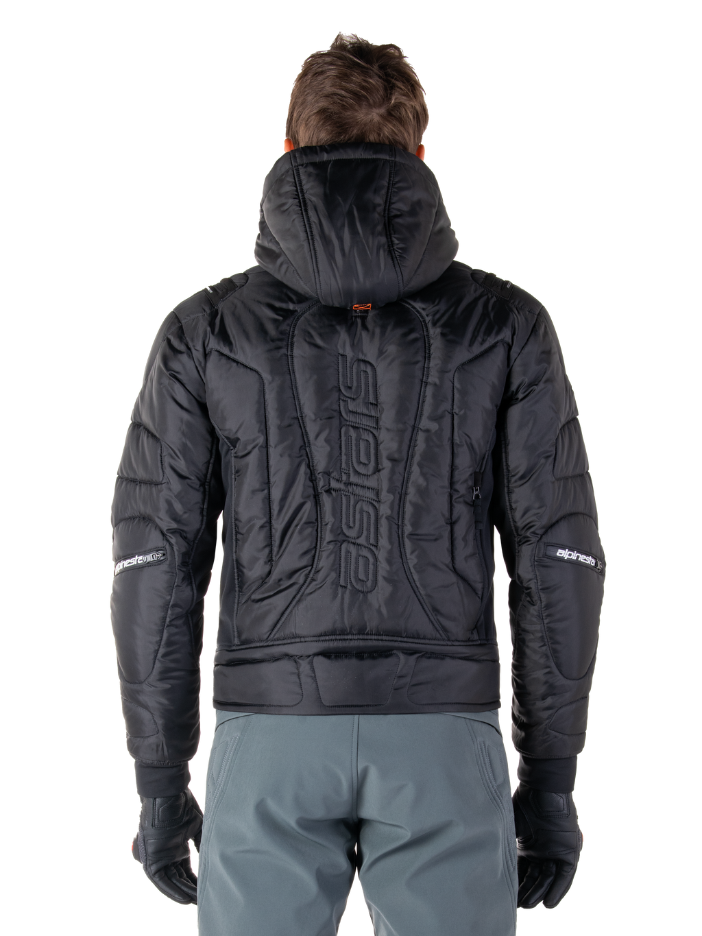 Giacca Alpinestars Mohobbs Waterproof, nero, vista posteriore che mostra la costruzione imbottita e trapuntata, marchio 'astars' verticale sul retro, cappuccio alzato, stile streetwear motociclistico contemporaneo