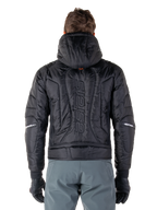 Giacca Alpinestars Mohobbs Waterproof, nero, vista posteriore che mostra la costruzione imbottita e trapuntata, marchio 'astars' verticale sul retro, cappuccio alzato, stile streetwear motociclistico contemporaneo