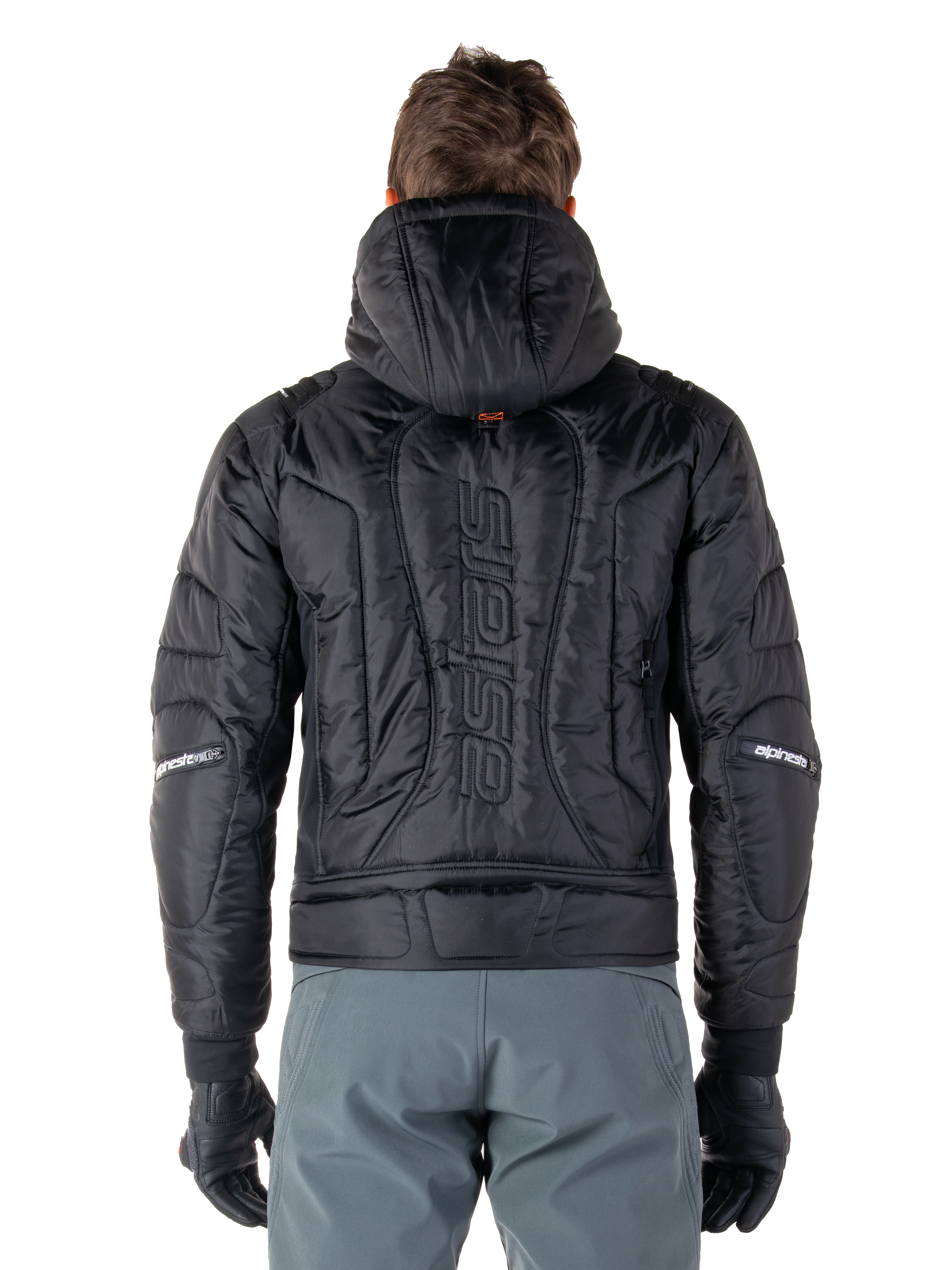 Giacca Alpinestars Mohobbs Waterproof, nero, vista posteriore che mostra la costruzione imbottita e trapuntata, marchio 'astars' verticale sul retro, cappuccio alzato, stile streetwear motociclistico contemporaneo