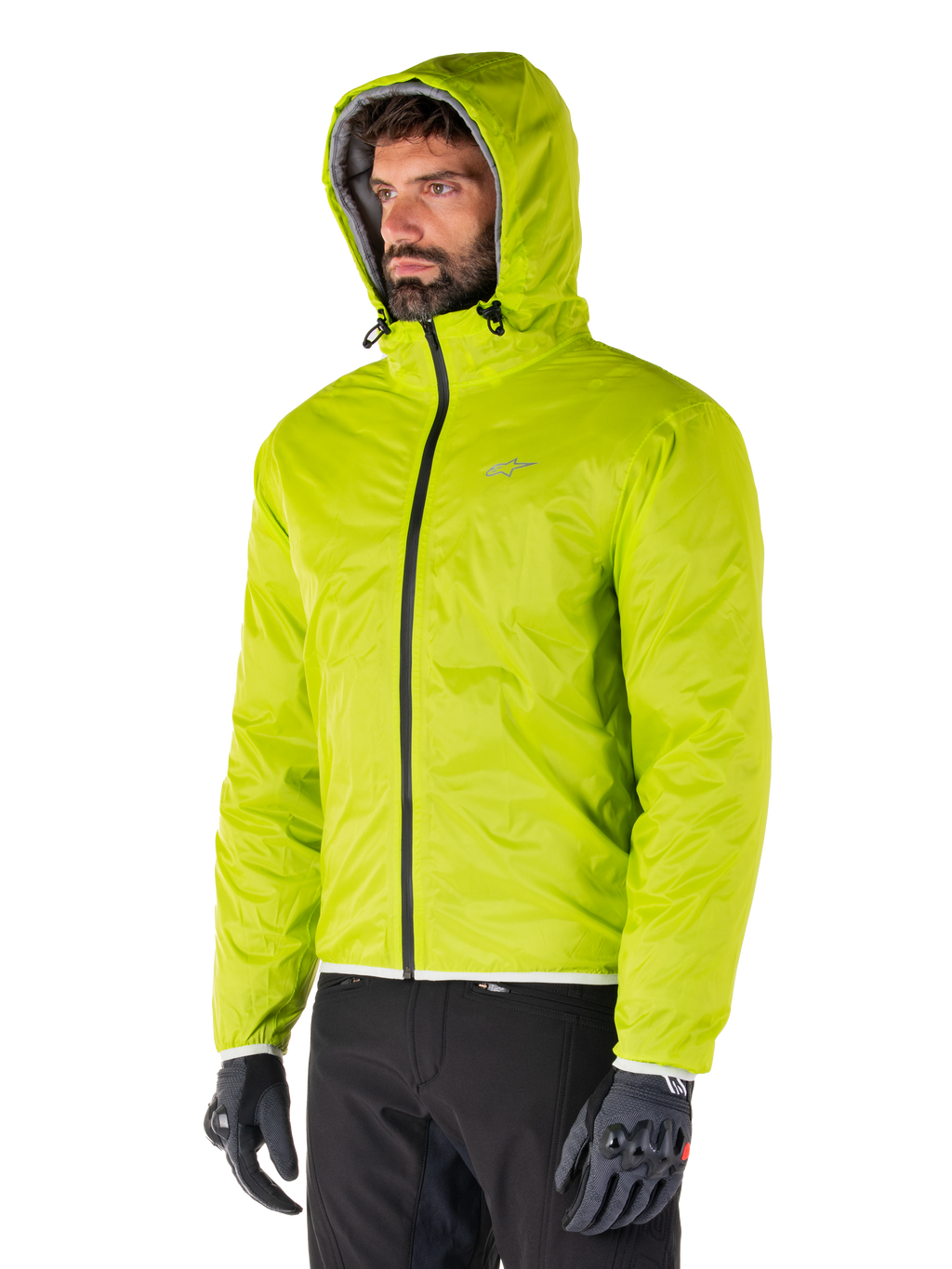 Giacca impermeabile Alpinestars Mohobbs, fodera antipioggia ripiegabile Lime Punch, giacca con cappuccio verde neon brillante indossata con pantaloni neri e guanti grigi, abbigliamento da moto ispirato allo streetwear urbano