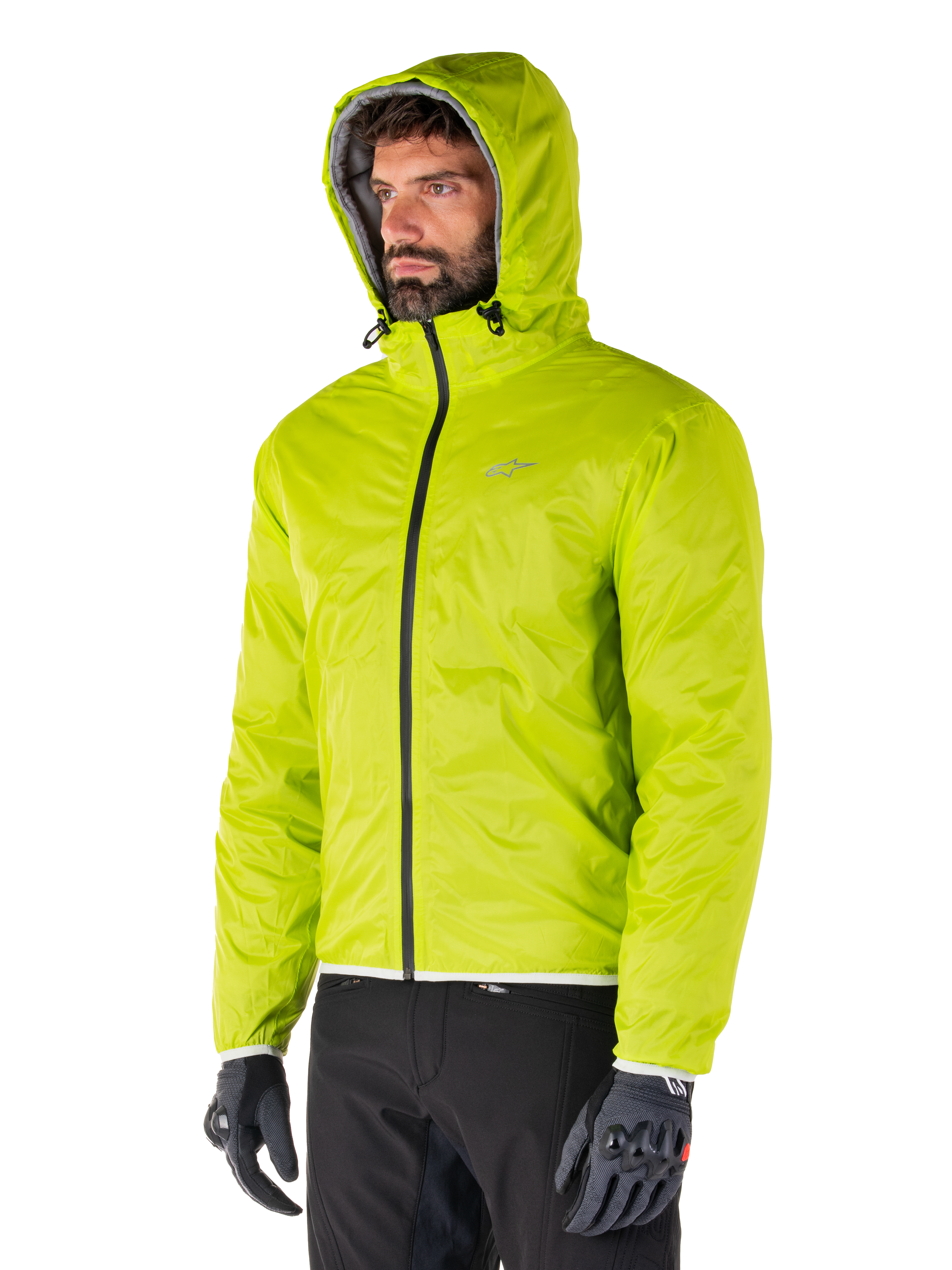 Giacca impermeabile Alpinestars Mohobbs, fodera antipioggia ripiegabile Lime Punch, giacca con cappuccio verde neon brillante indossata con pantaloni neri e guanti grigi, abbigliamento da moto ispirato allo streetwear urbano