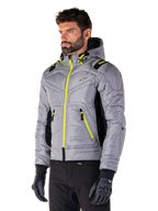Giacca Alpinestars Mohobbs Waterproof, Lunar Gray Lime Punch, giacca da moto bomber trapuntata da uomo con cerniere e dettagli coulisse giallo neon, indossata con pantaloni da guida e guanti neri, design moderno urban moto streetwear con profilo con cappuccio