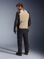 Alpinestars Andes Pro Drystar® XF Jacket, giacca da moto, color noce e nero con accenti rossi, vista posteriore su modello, design adventure touring con ampia tasca posteriore portaoggetti, indossata con pantaloni da moto e guanti neri.