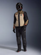 Alpinestars Andes Pro Drystar® XF Jacket in Walnut Aluminum, giacca da moto adventure indossata con pantaloni neri abbinati, casco adventure nero con maschera e stivali neri, caratterizzata da pannelli color sabbia e neri con dettagli rossi.