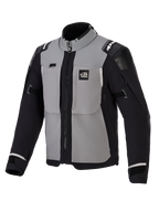 Giacca Alpinestars Andes Pro Drystar® XF, giacca da moto adventure, grigio scuro e nero, con pannelli grigi sul petto e maniche e fianchi neri, marchio 'ALL TERRA' sul petto, logo Alpinestars sulle spalle, costruzione in tessuto tecnico con cerniere di ventilazione e polsini regolabili.