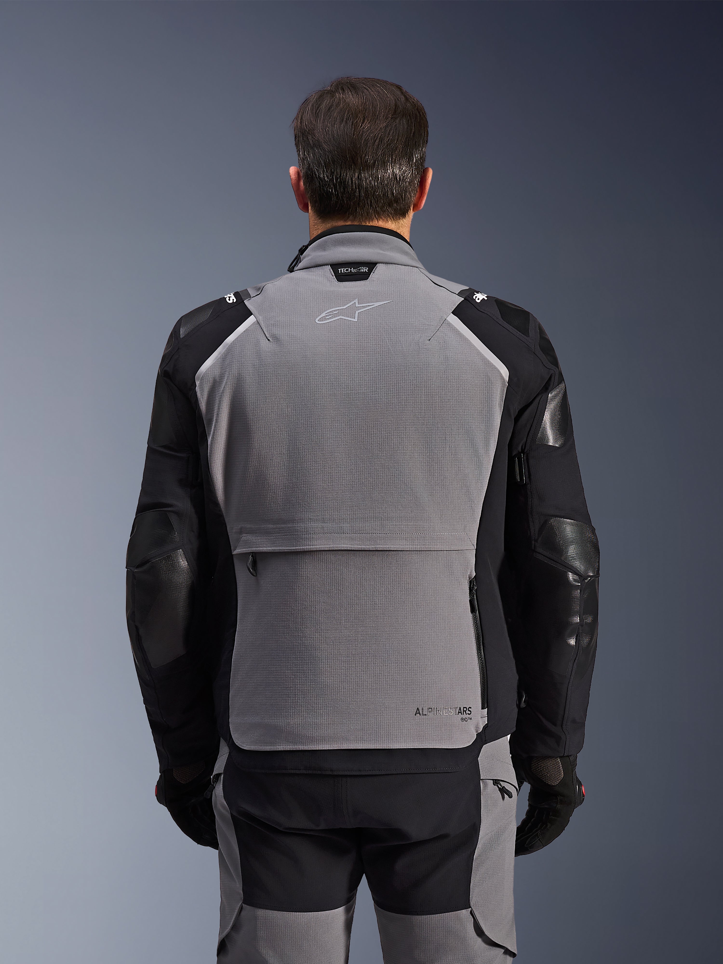 Alpinestars Andes Pro Drystar® XF Jacket, vista posteriore, grigio scuro e nero, giacca adventure touring con ampia tasca posteriore, marchio Tech-Air® Ready sul colletto e pannelli rinforzati sui gomiti.