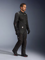 Modello con giacca Alpinestars Cusco Drystar® in nero, abbigliamento da moto adventure touring con pantaloni e stivali neri coordinati, design multitasche, marchio 'Drystar' sulla manica e patch con logo 'Terra'.