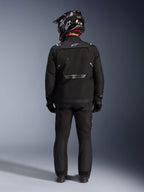 Alpinestars Giacca Cusco Drystar, giacca da moto adventure, nero, vista posteriore indossata con pantaloni coordinati e un casco bianco e nero, con marchio Alpinestars riflettente e ampi pannelli di ventilazione, robusta costruzione in tessuto per touring d'avventura su strada