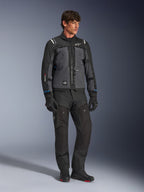 Giacca Alpinestars Cusco Drystar® in nero e grigio scuro, giacca tecnica da moto touring con pannelli multitono, indossata con pantaloni da moto e guanti neri coordinati, progettata per il touring su strada e adventure touring.