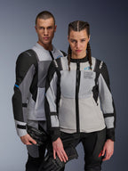 Giacche Alpinestars ST-2 Air e Stella ST-2 Air, grigio ghiaccio e nero, giacche da moto in tessuto con pannelli in rete e perforazioni laser, con marchio 'Alpinestars Exploration Equipment', indossate da modelli uomo e donna che tengono guanti da moto