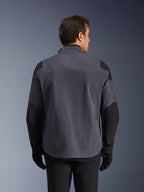 Alpinestars Maxdura Drystar®XF Laminated Armored Shell, giacca tecnica adventure, grigio scuro e nero, vista posteriore con pannelli rinforzati su spalle e gomiti, logo discreto sulla parte superiore della schiena, indossata con guanti e pantaloni neri, progettata per la protezione in ogni condizione atmosferica