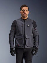 Alpinestars Maxdura Drystar®XF Laminated Armored Shell, giacca da moto adventure in grigio scuro e nero, vista frontale su modello, con ampie tasche cargo, logo 'All Terra' sul petto e cerniere di ventilazione, abbinata a guanti e pantaloni da guida neri.