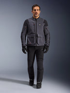 Maxdura Drystar®XF Laminated Armored Shell, giacca da moto, Deep Gray Black, indossata da un modello con pantaloni e guanti neri, con ampie tasche cargo, dettagli delle cerniere rossi e marchio All Terra, abbigliamento tecnico da moto adventure