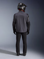 Alpinestars Maxdura Drystar®XF Laminated Armored Shell, Deep Gray Black, vista posteriore a figura intera, giacca tecnica adventure con pannelli rinforzati, indossata con pantaloni da guida neri, guanti e casco off-road bianco e nero, completo coordinato dual-sport