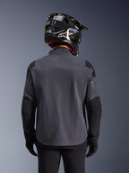 Maxdura Drystar®XF Laminated Armored Shell, giacca da moto adventure, Deep Gray Black, vista posteriore che mostra la costruzione in tessuto tecnico e i pannelli rinforzati, indossata con casco in fibra di carbonio nero, pantaloni da guida neri e guanti