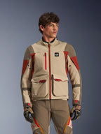 Alpinestars Maxdura Drystar®XF Laminated Armored Shell, colore Aluminum Walnut Rust Brown, giacca da moto adventure indossata da un modello, con grandi tasche cargo frontali e accenti tecnici rossi, abbinata a pantaloni e guanti da guida adventure coordinati