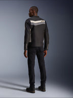 Modello maschile visto da dietro che indossa la giacca Alpinestars T-Dyno WR in Nero Grigio Scuro Ecru, giacca da moto in tessuto con striscia orizzontale e logo a stella sul retro, abbinata a pantaloni da guida e stivali neri, estetica urban motorcycle gear.