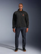 Giacca Alpinestars Revved WR nera, indossata da un modello con jeans blu scuro e sneakers nere, vista frontale, con chiusura a bottoni a pressione e logo ricamato in 3D sul petto, abbigliamento da moto urban contemporary