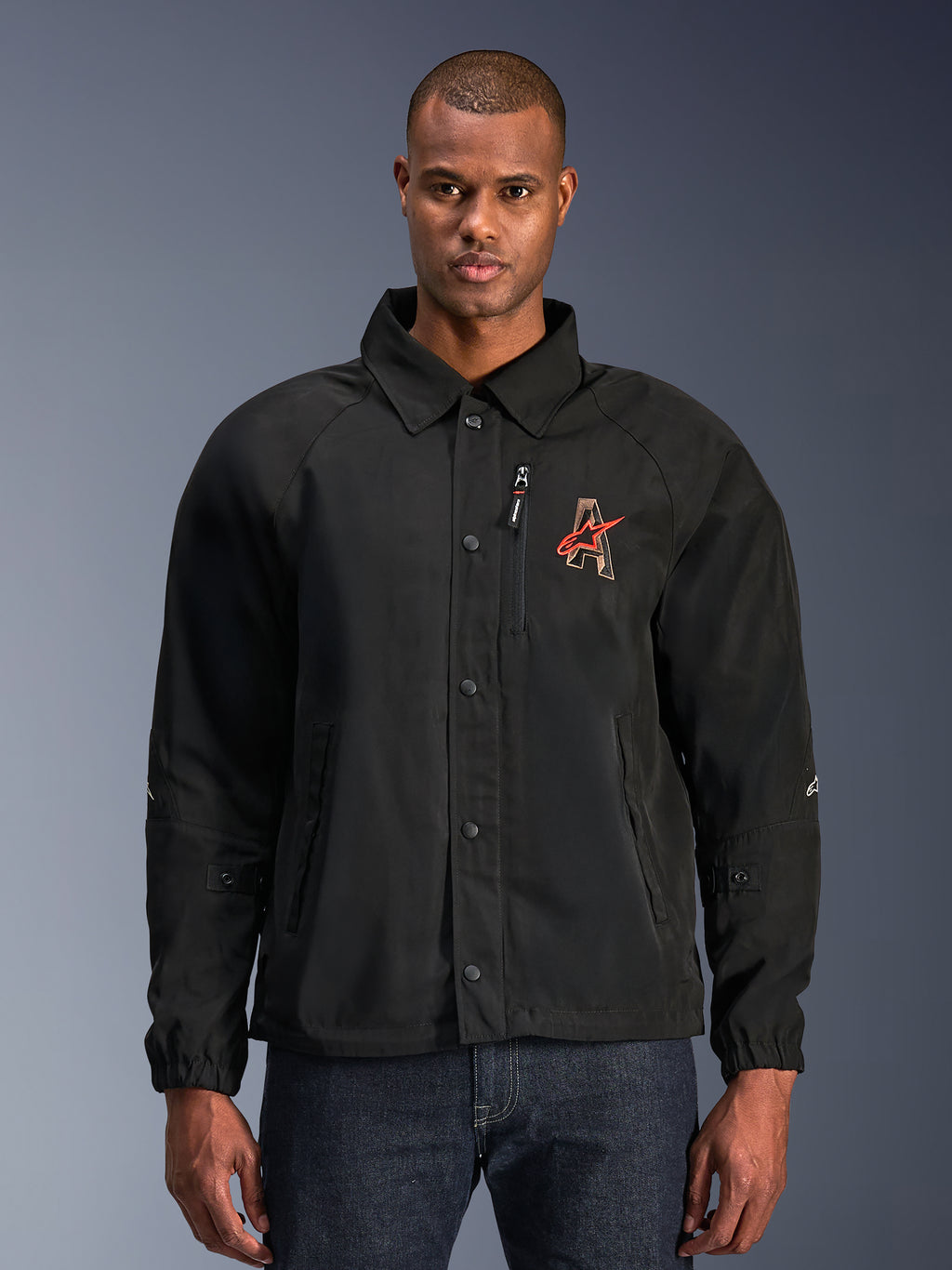 Alpinestars Revved WR Jacket, giacca da moto nera, con colletto stile camicia e chiusura frontale con bottoni a pressione, logo 'A' rosso ricamato sul petto, tasca pettorale con zip verticale, polsini elastici, design urban coach jacket