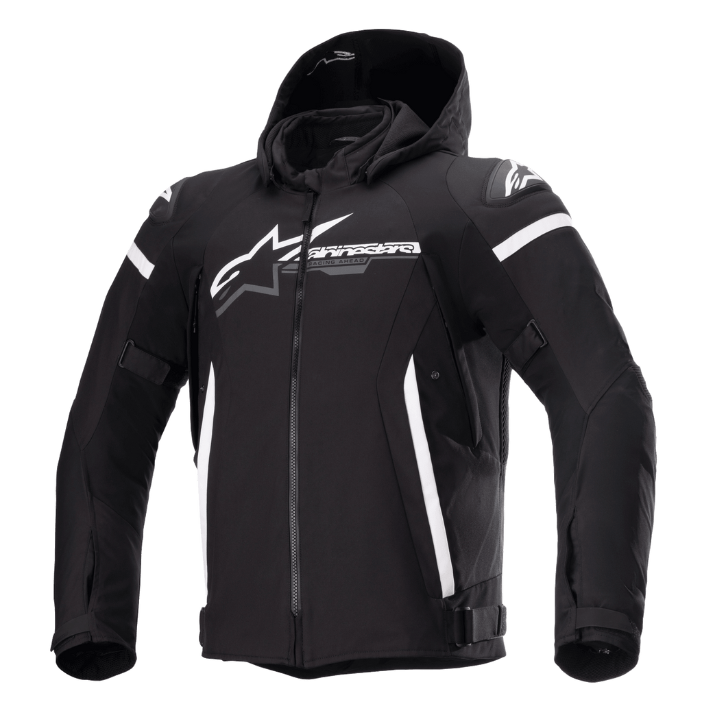 Alpinestars Zaca Waterproof Jacket, giacca da moto nera con cappuccio rimovibile, grande logo Alpinestars bianco sul petto, strisce bianche sulla parte superiore delle braccia e accenti laterali verticali, cerniera frontale, imbottitura rinforzata sulle spalle, cinghie regolabili in vita e sulle braccia, costruzione in tessuto softshell