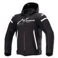 Alpinestars Zaca Waterproof Jacket, giacca da moto nera con cappuccio rimovibile, grande logo Alpinestars bianco sul petto, strisce bianche sulla parte superiore delle braccia e accenti laterali verticali, cerniera frontale, imbottitura rinforzata sulle spalle, cinghie regolabili in vita e sulle braccia, costruzione in tessuto softshell