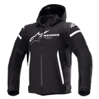 Alpinestars Zaca Waterproof Jacket, giacca da moto nera con cappuccio rimovibile, grande logo Alpinestars bianco sul petto, strisce bianche sulla parte superiore delle braccia e accenti laterali verticali, cerniera frontale, imbottitura rinforzata sulle spalle, cinghie regolabili in vita e sulle braccia, costruzione in tessuto softshell