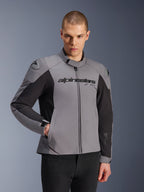 Giacca impermeabile Alpinestars SMX, grigio scuro e nero, indossata da un modello uomo, con logo 'alpinestars' sul petto, protezione per le spalle DFS Lite, design sportivo in tessuto e softshell per guida su strada