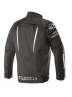 Giacca Impermeabile Alpinestars Gunner V2, vista posteriore, nero e bianco, costruzione in tessuto con accenti bianchi verticali, grande logo Alpinestars sulla parte inferiore della schiena e logo A-star sulla spalla, abbigliamento per guida urbana