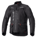 Giacca Alpinestars Bogota Pro Drystar, giacca moto touring completamente nera, accenti grigi e rossi, con ampi pannelli di ventilazione sul petto, tasche impermeabili con tiretti rossi, collo protettivo alto e struttura in tessuto resistente per il mototurismo d'avventura.