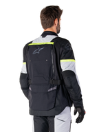 Alpinestars Giacca Bogotá Pro Drystar®, giacca adventure touring, Nero Ice Gray e Giallo Fluo, vista posteriore con ampio pannello tasca posteriore con marchio 'TECH TOURING', logo Alpinestars e accenti fluorescenti, abbigliamento tecnico in tessuto