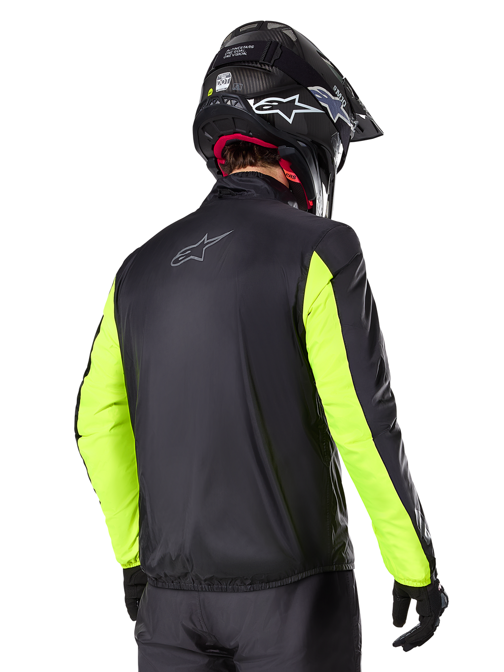 Giacca Alpinestars Bogotá Pro Drystar®, vista posteriore, nero con maniche giallo fluo, indossata da un pilota con casco e guanti neri, abbigliamento da moto adventure touring ad alta visibilità con finitura in tessuto tecnico.
