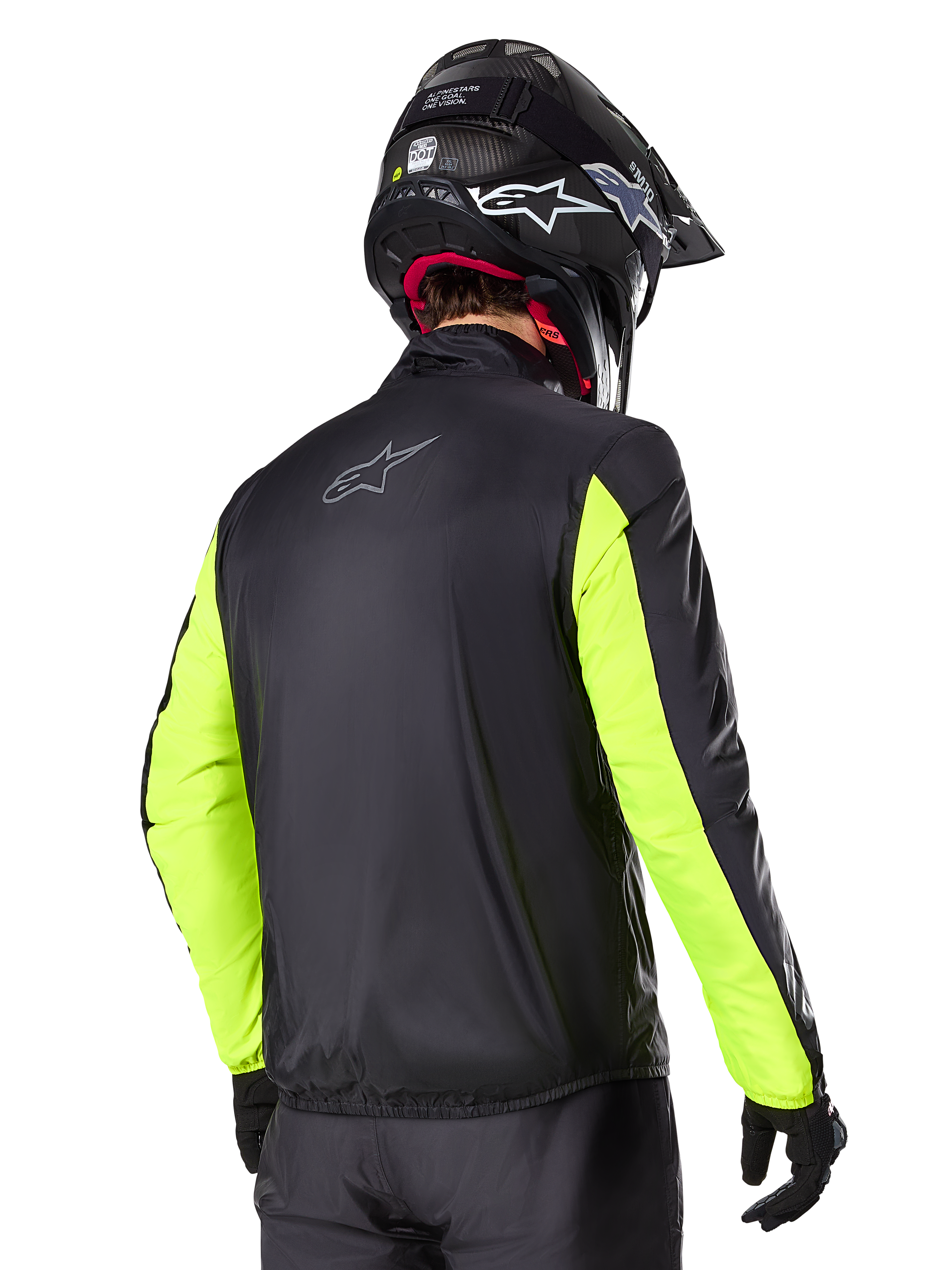 Giacca Alpinestars Bogotá Pro Drystar®, vista posteriore, nero con maniche giallo fluo, indossata da un pilota con casco e guanti neri, abbigliamento da moto adventure touring ad alta visibilità con finitura in tessuto tecnico.