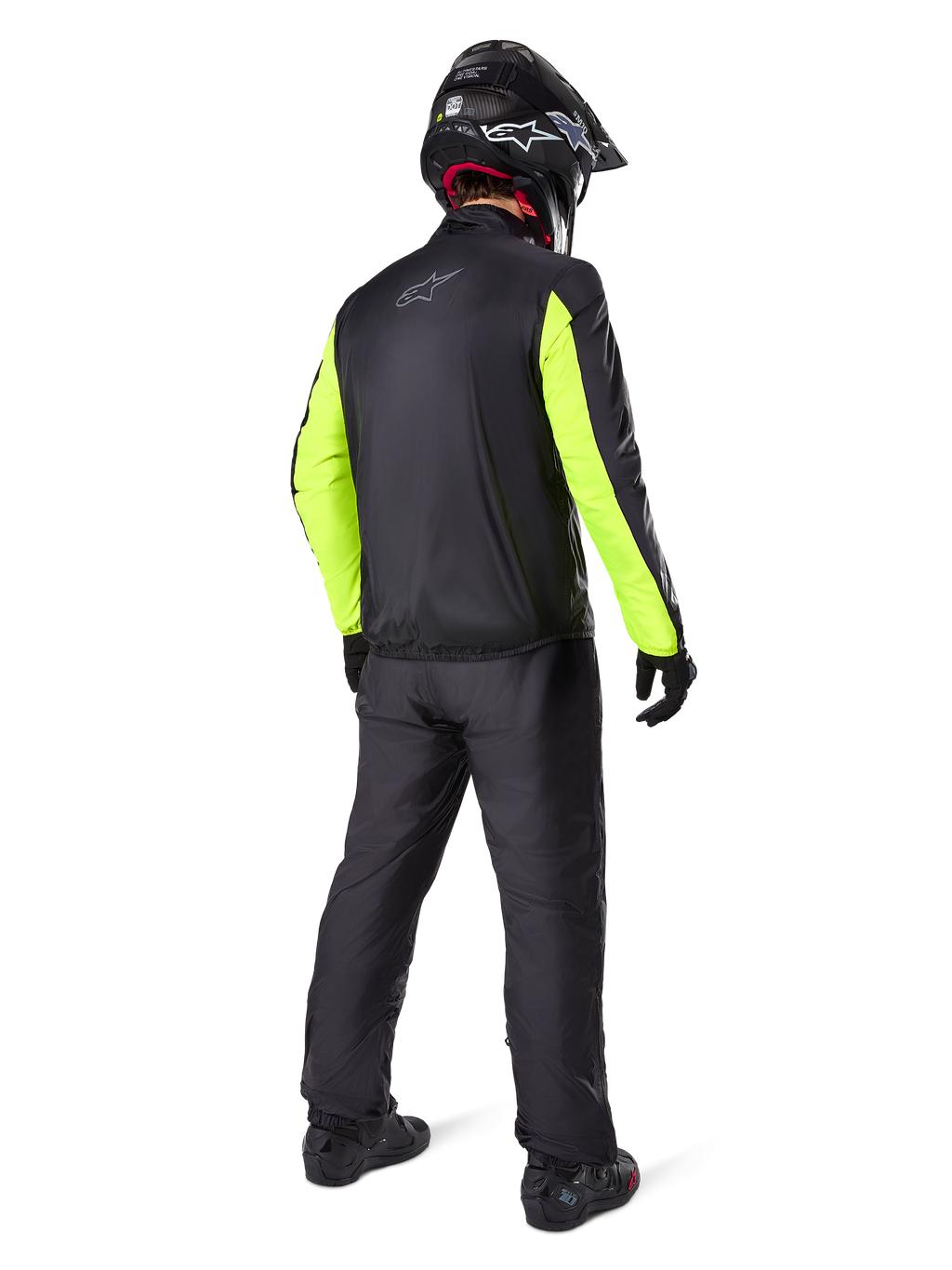 Motociclista visto di spalle con la giacca Alpinestars Bogotá Pro Drystar®, nera con maniche giallo fluo brillante, pantaloni e casco neri coordinati, abbigliamento tecnico adventure per tutte le stagioni