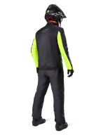 Motociclista visto di spalle con la giacca Alpinestars Bogotá Pro Drystar®, nera con maniche giallo fluo brillante, pantaloni e casco neri coordinati, abbigliamento tecnico adventure per tutte le stagioni