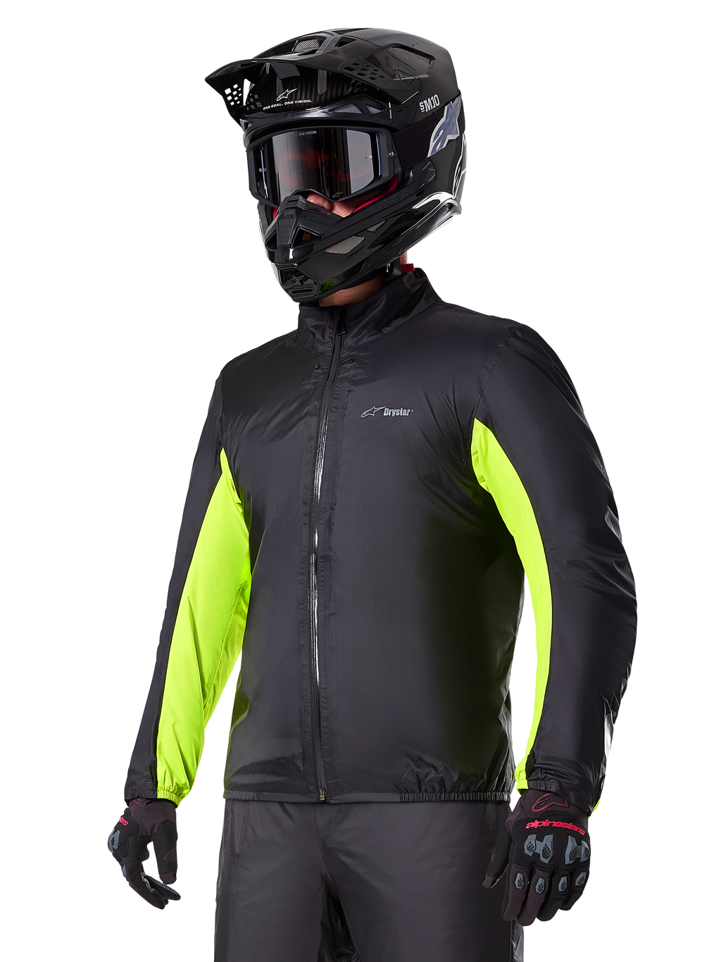 Alpinestars Bogotá Pro Drystar® Jacket waterproof liner, fodera impermeabile nera con accenti giallo fluo sulle maniche, indossata da un pilota con casco nero e maschera, abbigliamento tecnico da moto.