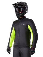 Alpinestars Bogotá Pro Drystar® Jacket waterproof liner, fodera impermeabile nera con accenti giallo fluo sulle maniche, indossata da un pilota con casco nero e maschera, abbigliamento tecnico da moto.