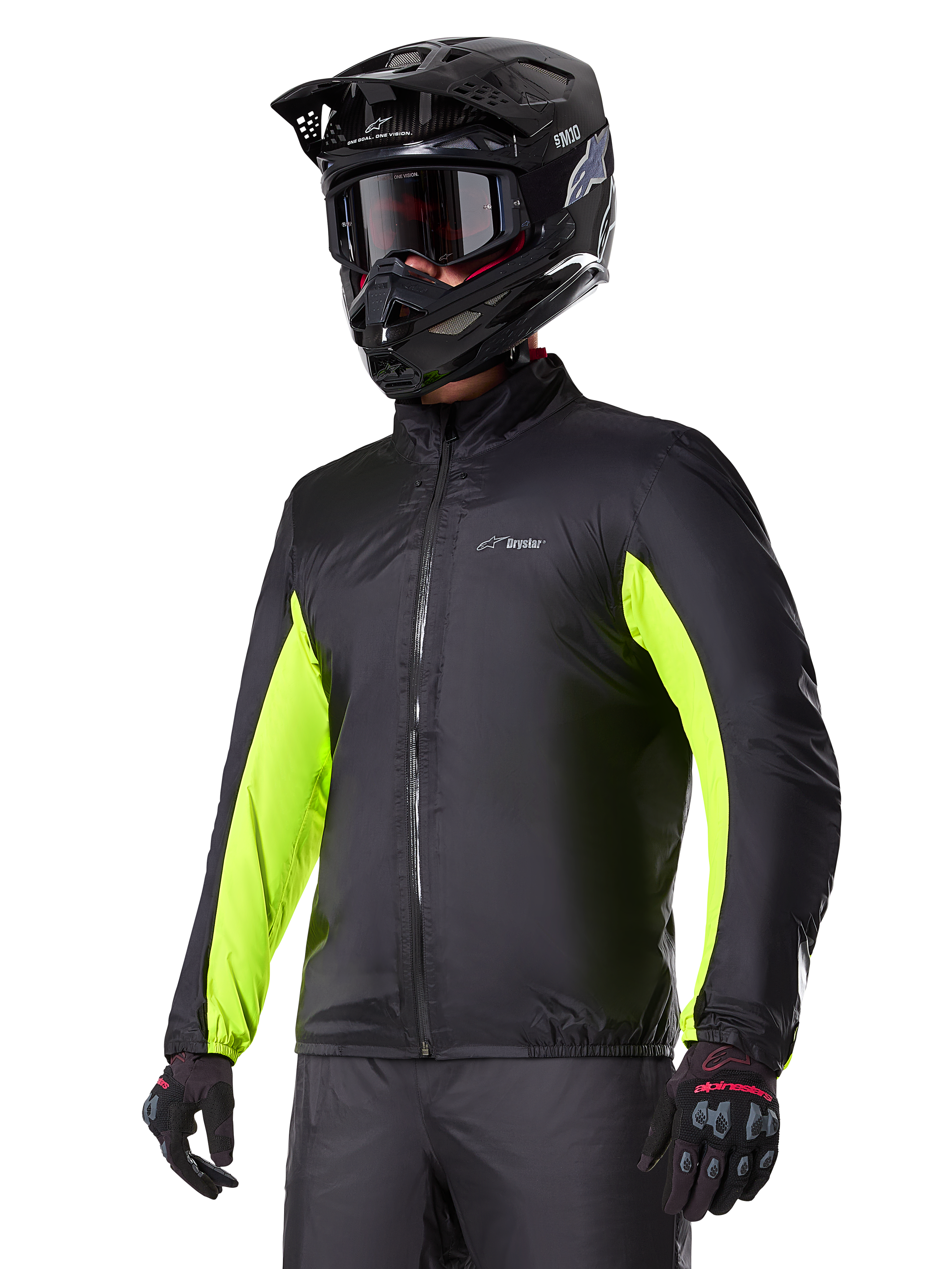 Alpinestars Bogotá Pro Drystar® Jacket waterproof liner, fodera impermeabile nera con accenti giallo fluo sulle maniche, indossata da un pilota con casco nero e maschera, abbigliamento tecnico da moto.