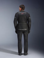 Giacca e pantaloni Alpinestars Andes Air Drystar®, completo da moto touring nero, vista posteriore del pilota, con pannelli in rete, logo a stella rossa e marchio Alpinestars riflettente sulla giacca, indossato con guanti e stivali neri.