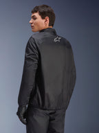Giacca Alpinestars Andes Air Drystar®, membrana impermeabile staccabile in nero, vista posteriore su un modello maschile, con un piccolo logo Alpinestars bianco sulla parte superiore della schiena, abbinata a guanti da moto neri