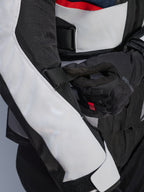 Alpinestars Andes Air Drystar® Jacket in Deep Blue Black Ice Gray, vista ravvicinata della cinghia regolabile sulla manica e dei pannelli di ventilazione in rete, resistente costruzione in tessuto per l'adventure touring
